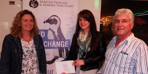 Vlnr is Shereen van der Merwe, Cari du Preez en Johan Burmeister, met Cari wat Johan se twee pryse oorhandig het en Johan wat een daarvan aan Shereen oorhandig het